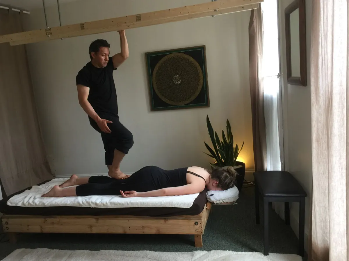 Abi Maldonado giving an Ashiatsu barefoot massage using overhead balance bars